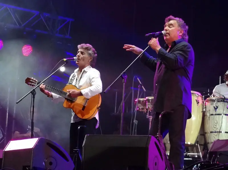 The Gipsy Kings performing on stage with guitars and congas