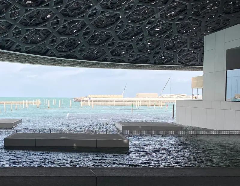 Looking from beneath the dome of Louvre Abu Dhabi across the water towards the Gulf